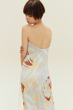 Back view of woman wearing spaghetti strap dress with brown, beige, white print