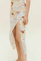Close up of high slit on dress with brown, beige, white print