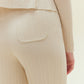 Close up back view of woman wearing off white knit pants with pocket