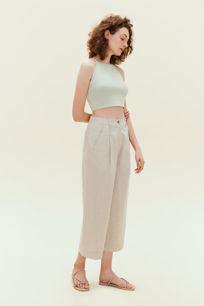 Woman standing wearing light green colored tank top with khaki capris