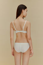 back of woman in white silk bra and underwear