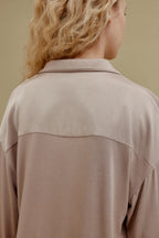 Back view of woman wearing tan pajama shirt