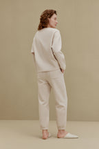 Back of woman in off-white top and pants
