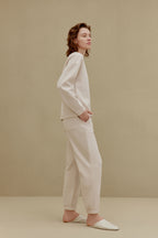 Side view of woman wearing off-white top and pants