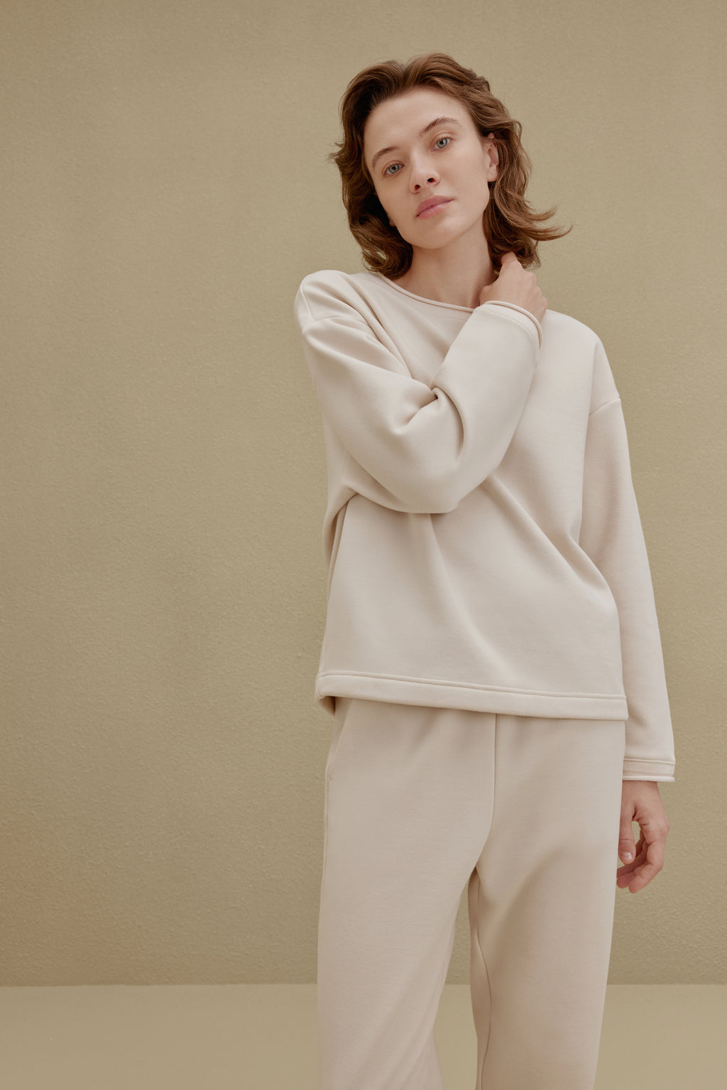 Woman wearing an off-white top and pants