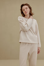 Woman wearing an off-white top and pants