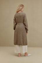 Back of woman in brown long knitted coat