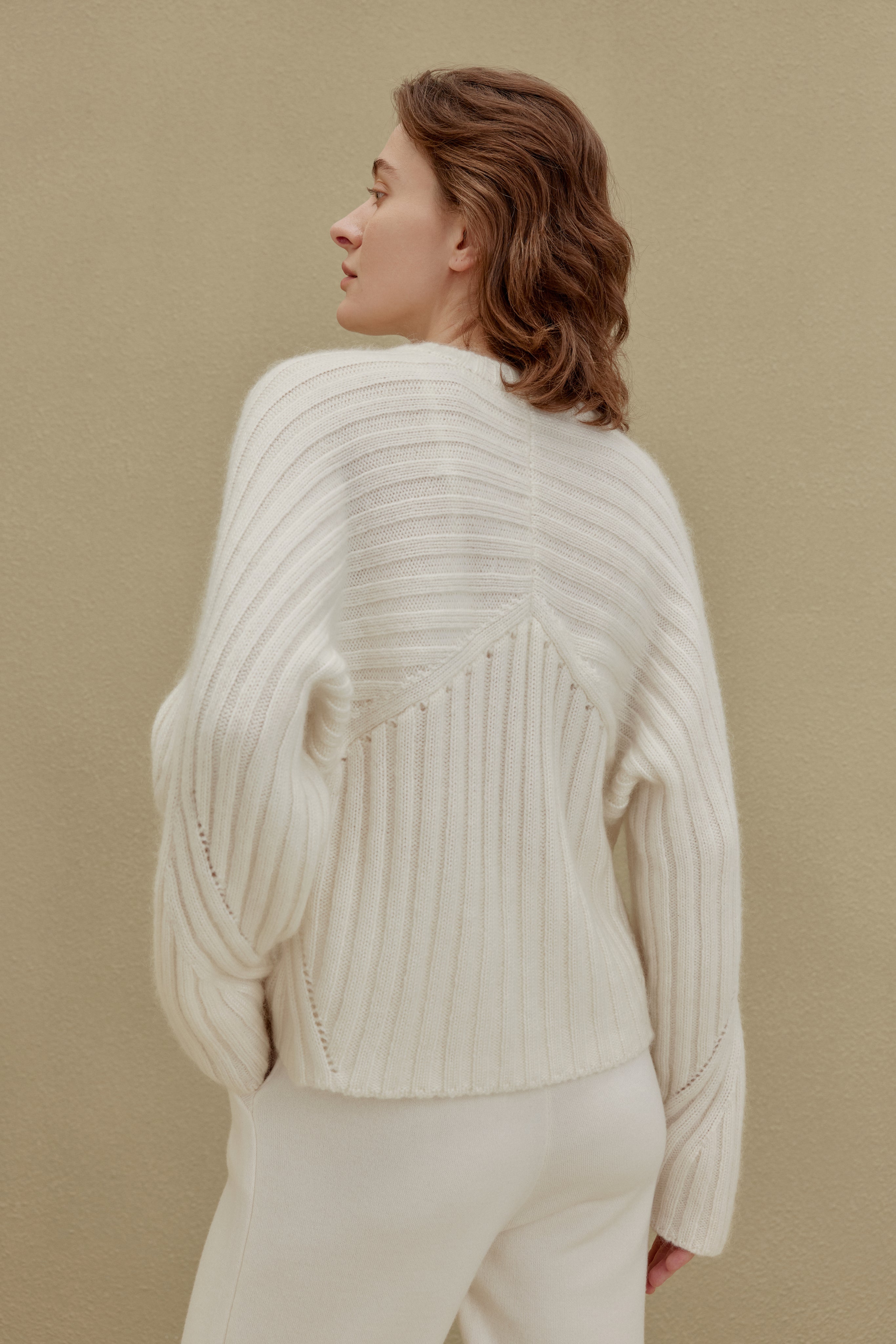back of women in white ribbed sweater