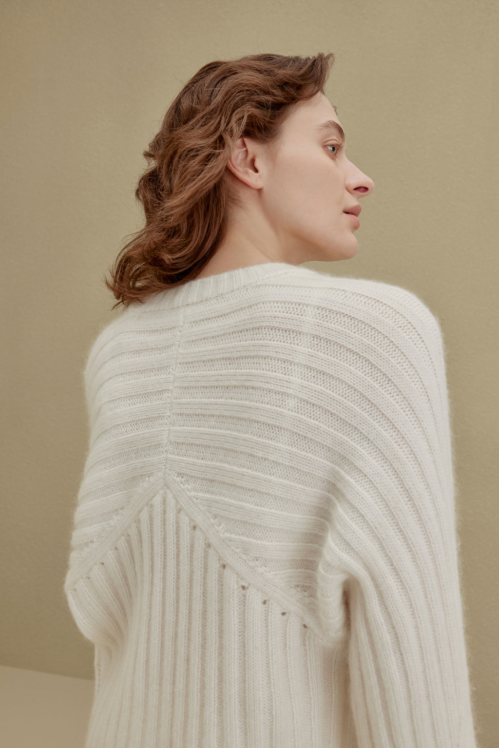 back of women in white ribbed sweater
