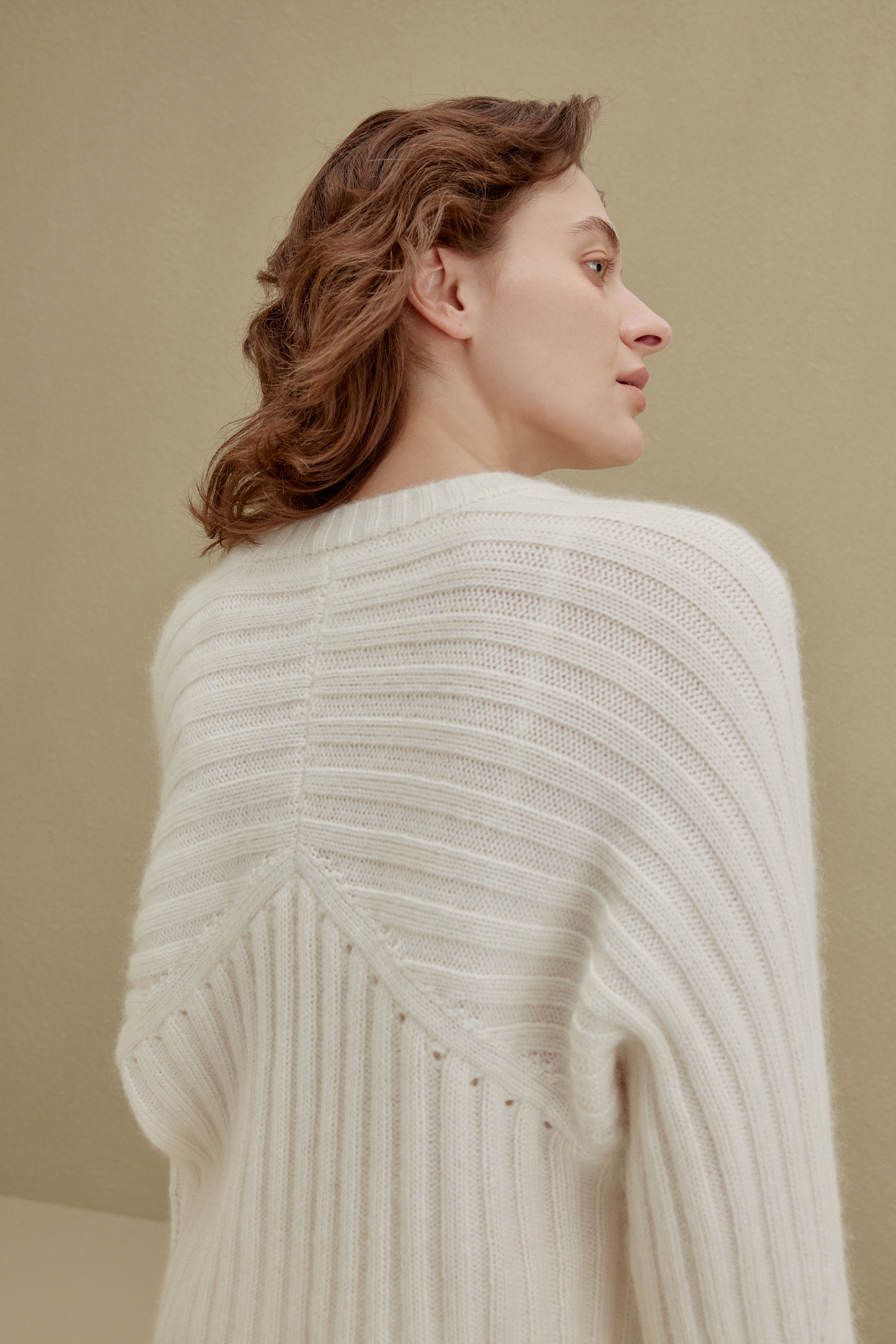 back of women in white ribbed sweater