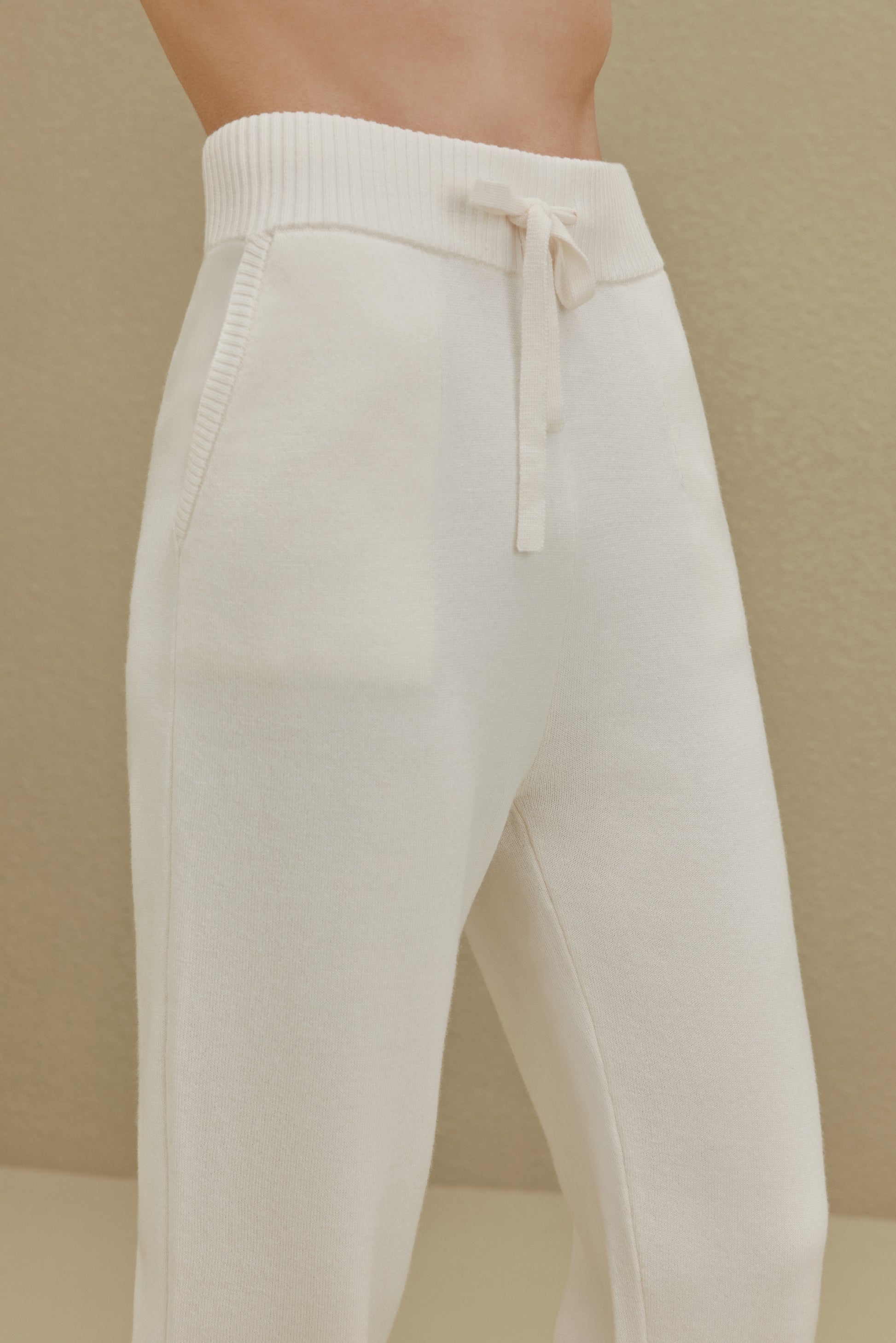 close up view of women in white knitted joggers