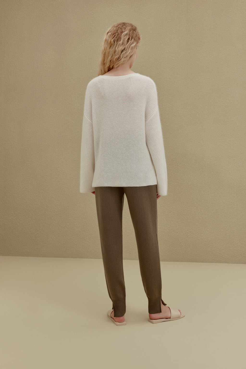 back of women in white knitted top and brown joggers