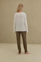 back of women in white knitted top and brown joggers