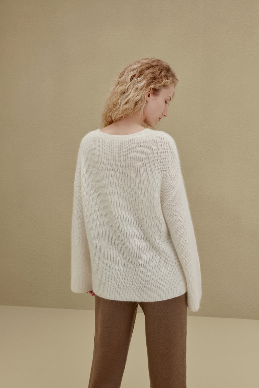 back of women in white sweater and brown knitted joggers