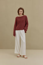 women in red sweater and white pants