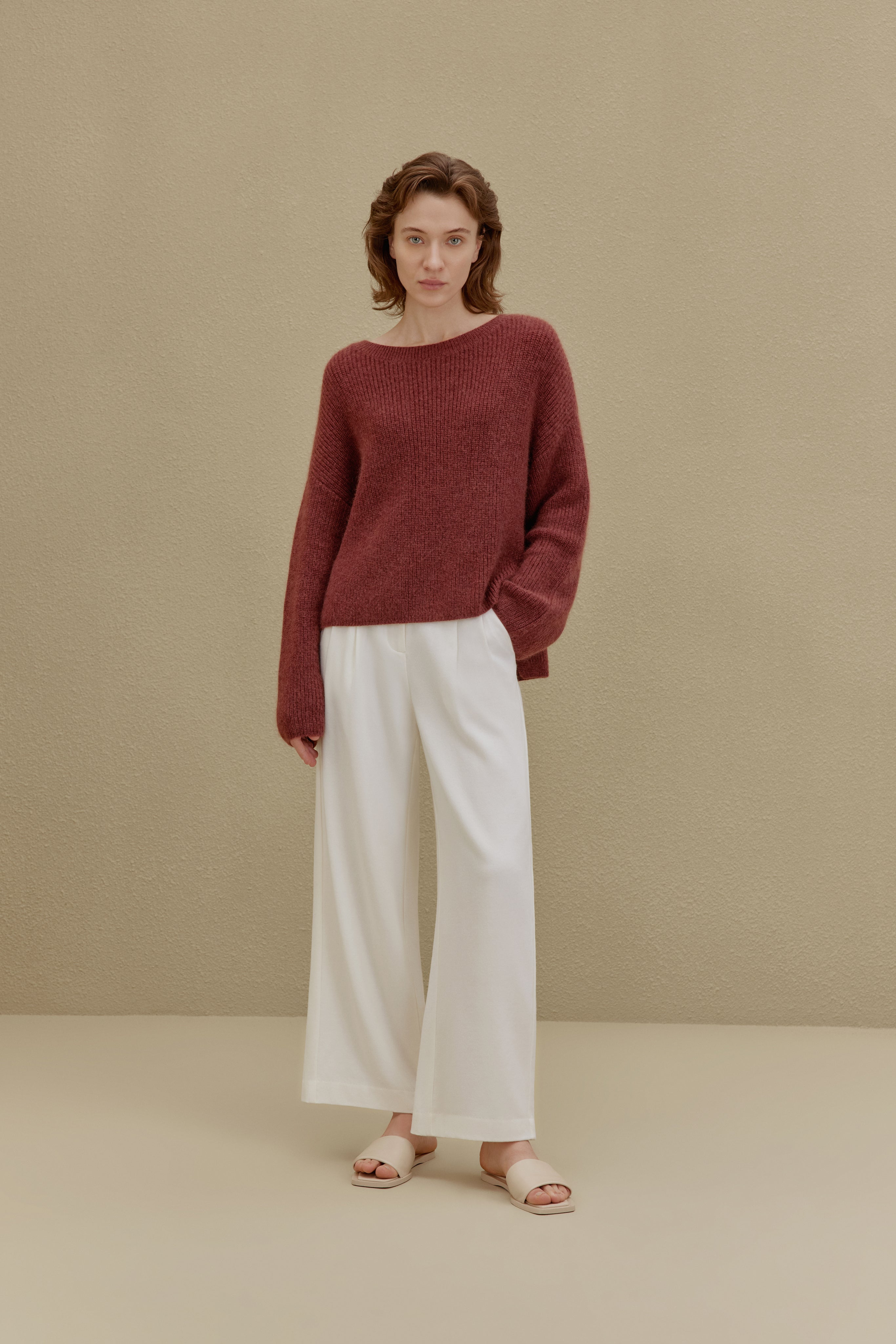 women in red sweater and white pants
