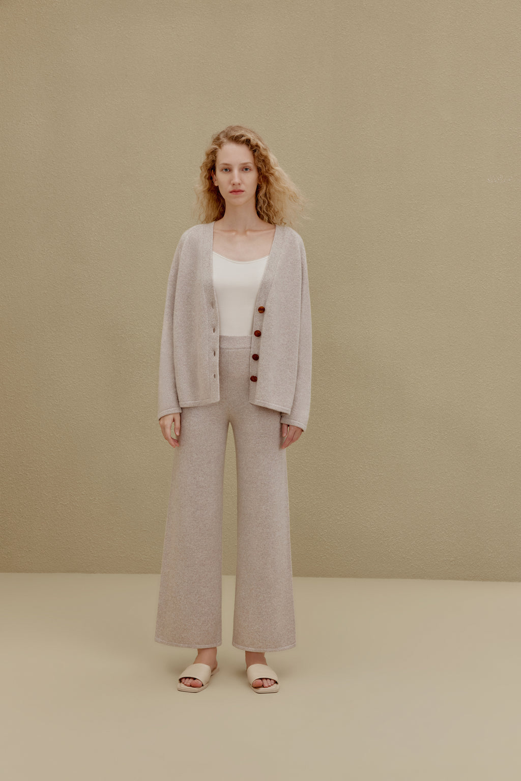 Woman in off white top and wide-leg pants