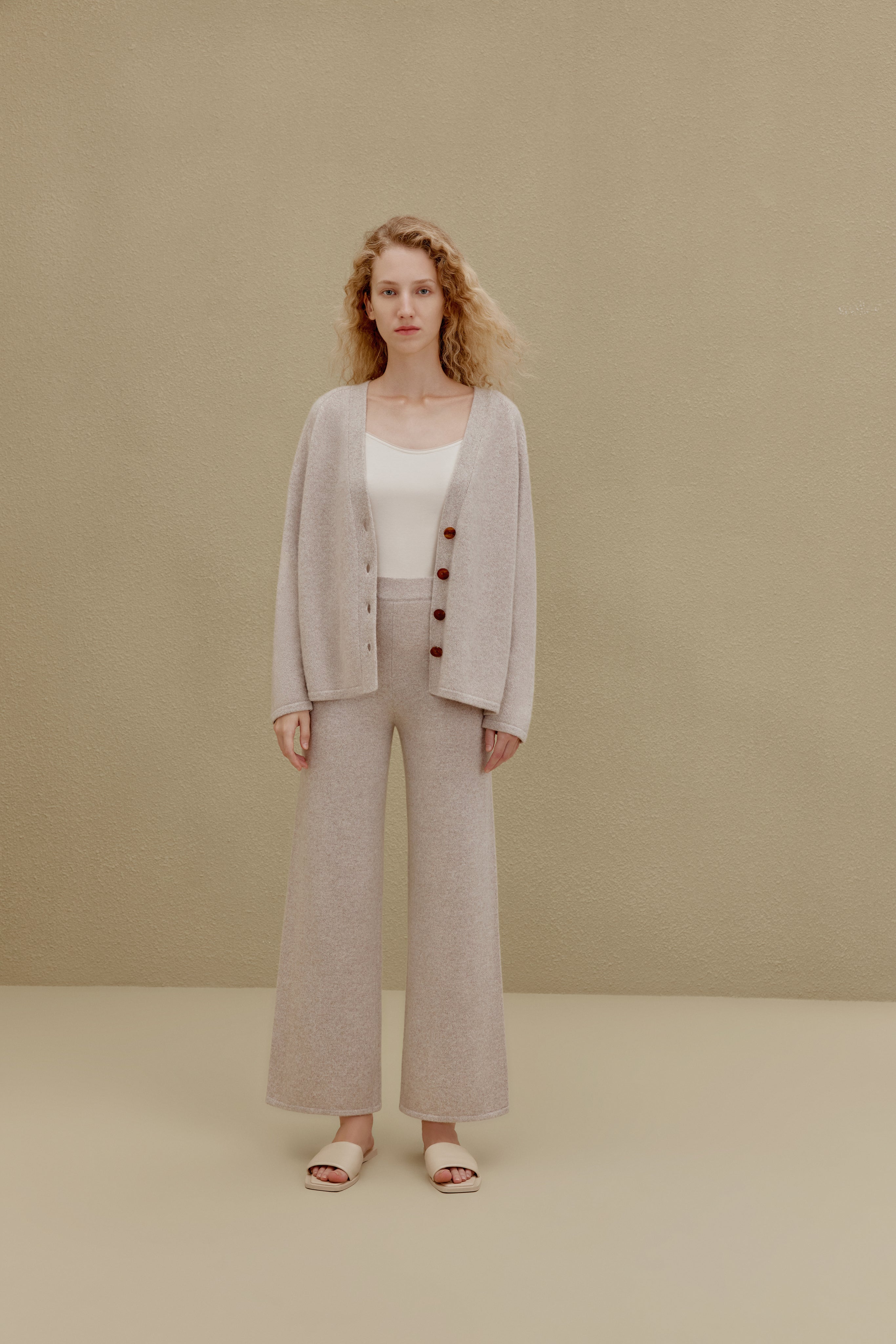 Woman in off white top and wide-leg pants