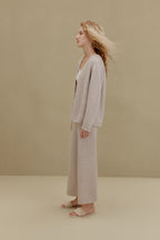 Side view of woman wearing off-white top and wide-leg pants