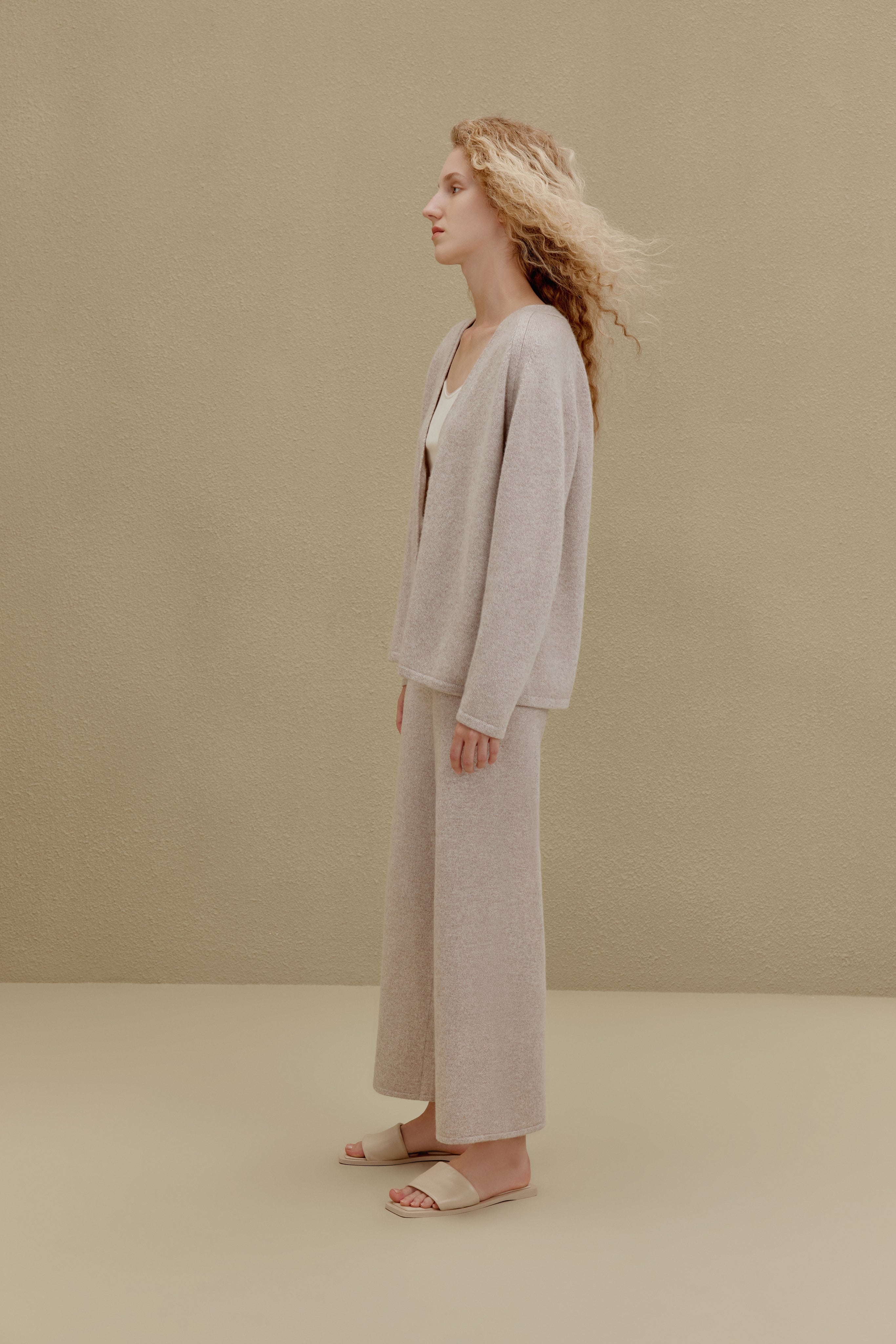 Side view of woman wearing off-white top and wide-leg pants