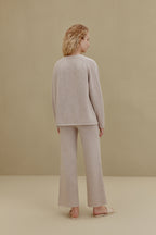 Back view of woman wearing off-white top and wide-leg pants