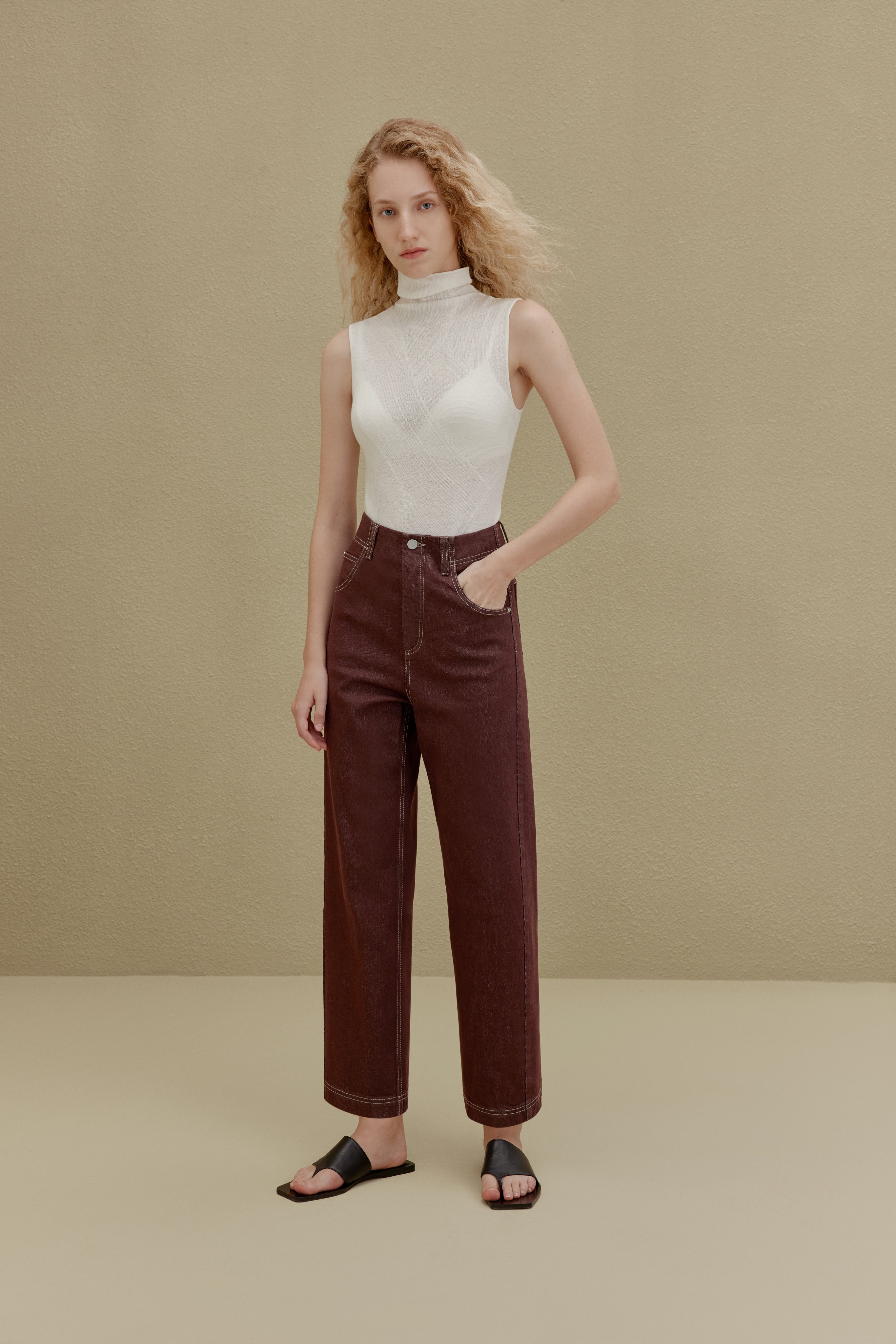 woman in white sleeveless top and brown pants