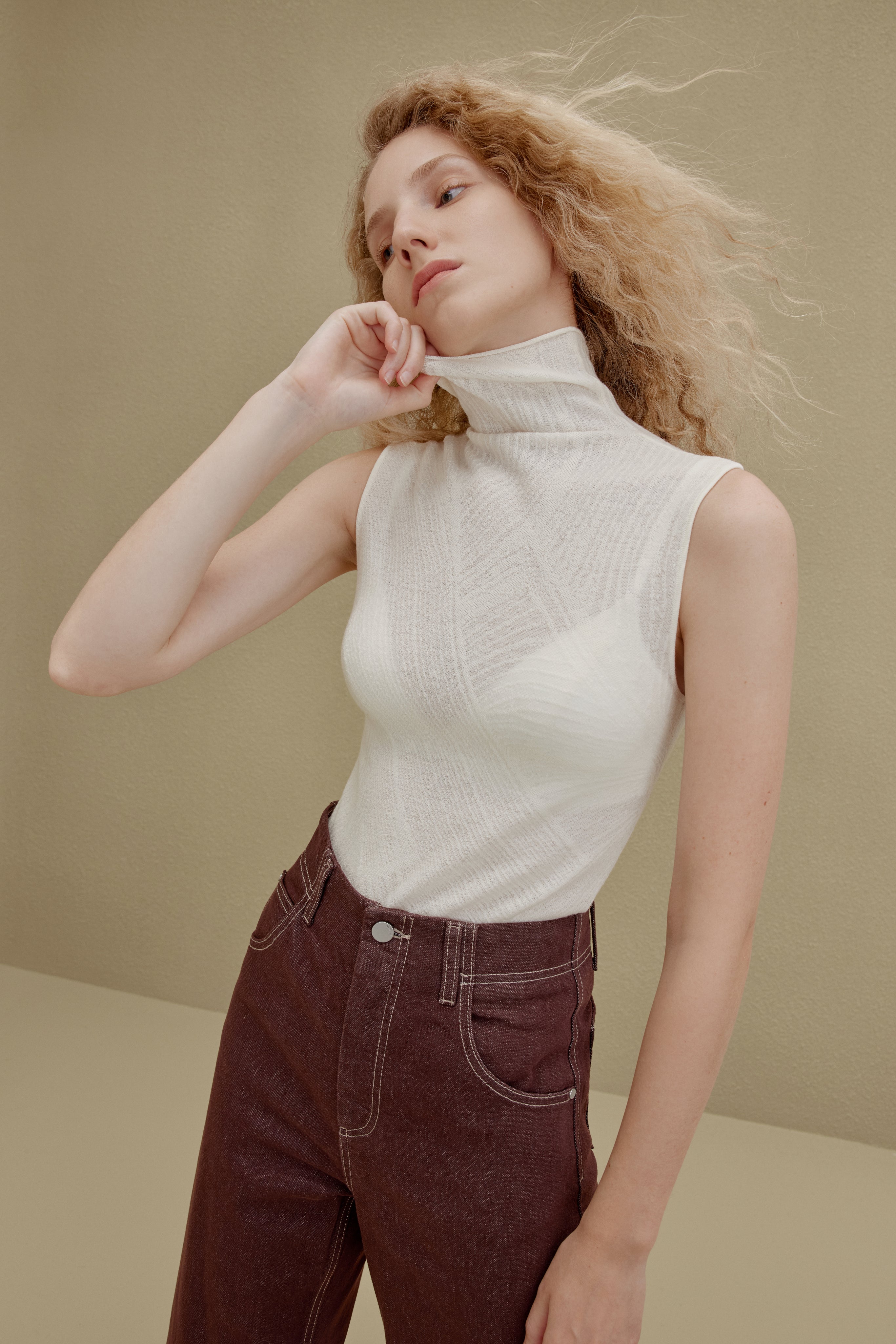woman in white sleeveless top and brown pants