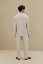 Back view of man in off-white pajamas