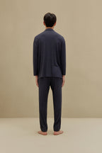 Back view of man in off-white pajamas