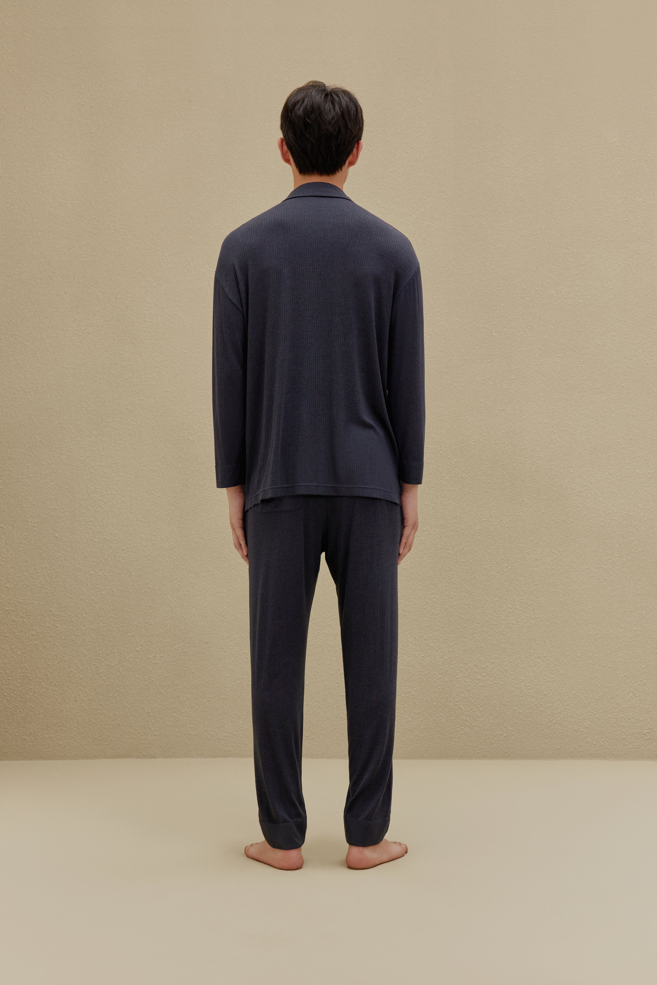 Back view of man in off-white pajamas
