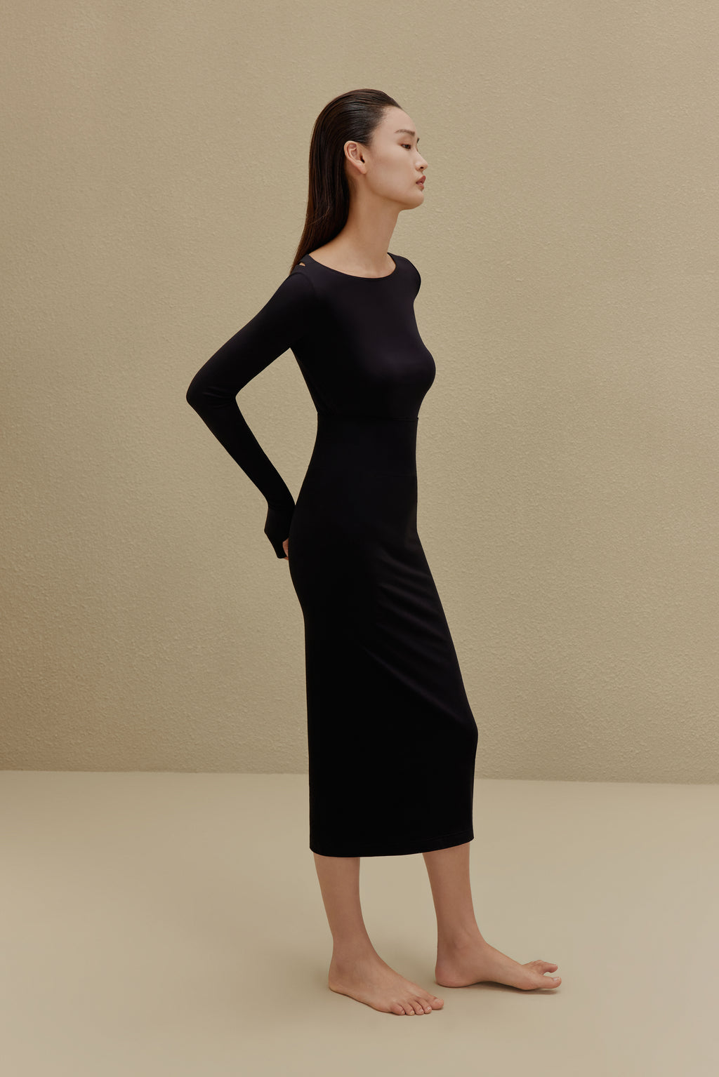 side of woman in black long sleeve top and midi skirt