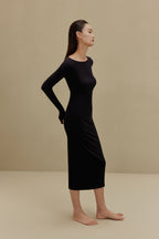 side of woman in black long sleeve top and midi skirt