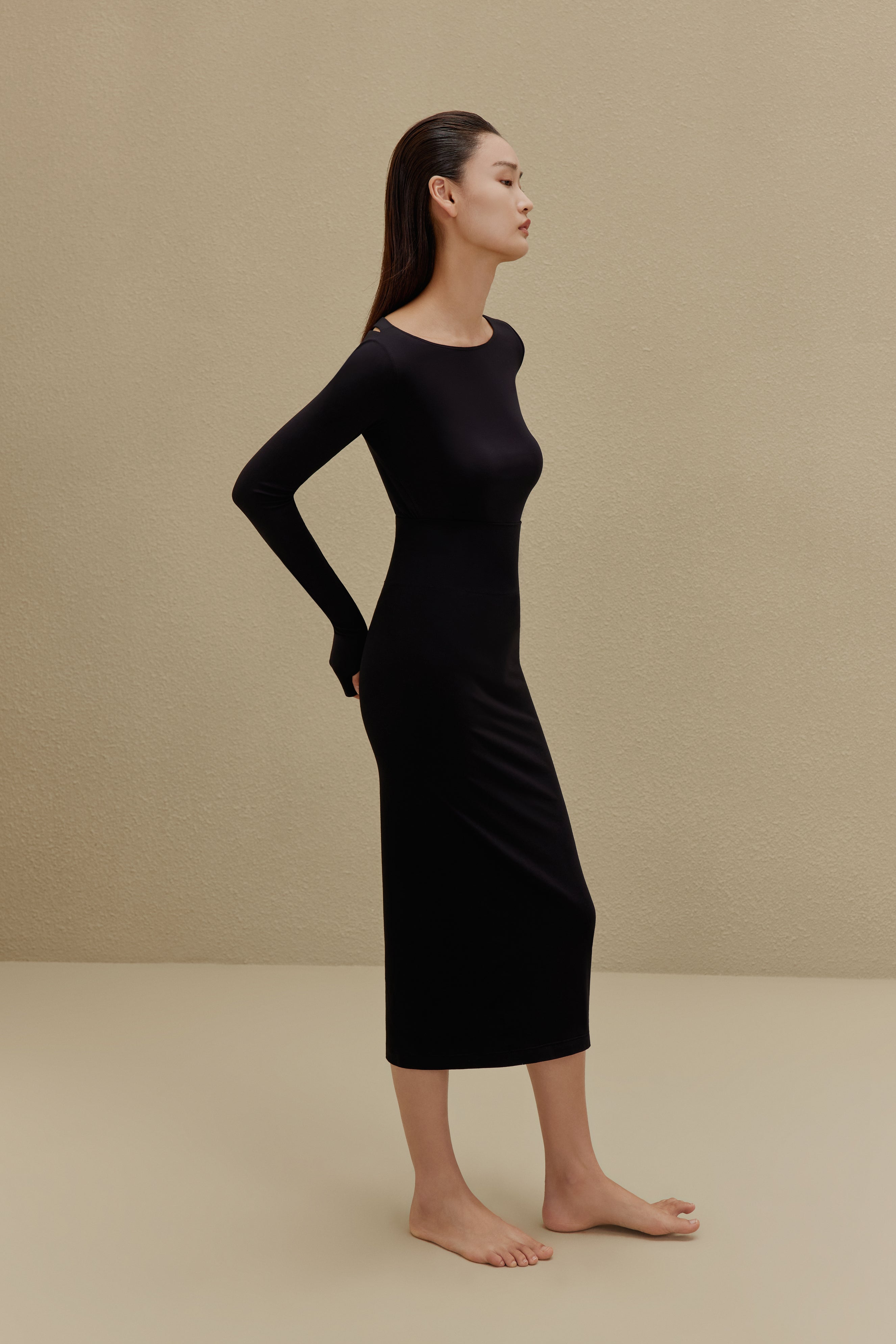 side of woman in black long sleeve top and midi skirt