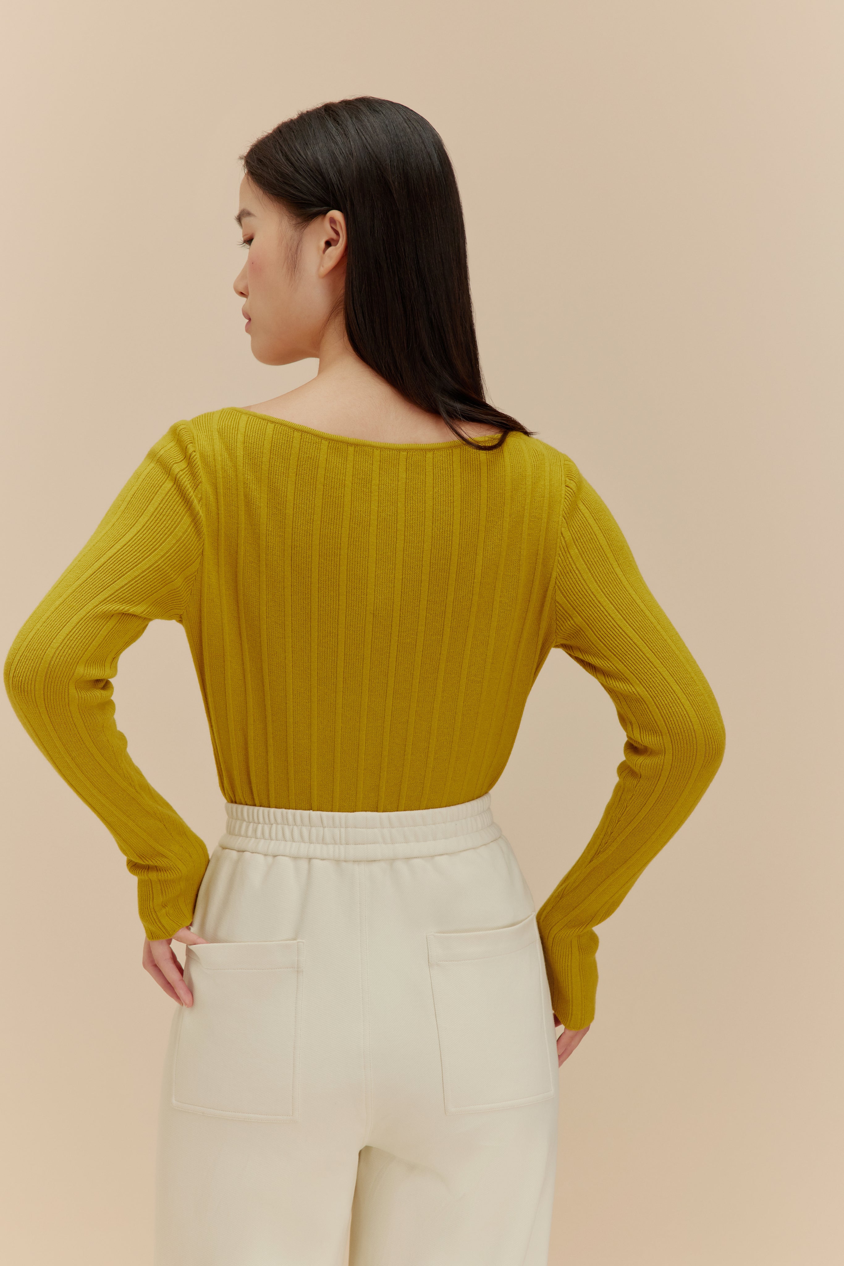 back of woman in golden yellow cardigan
