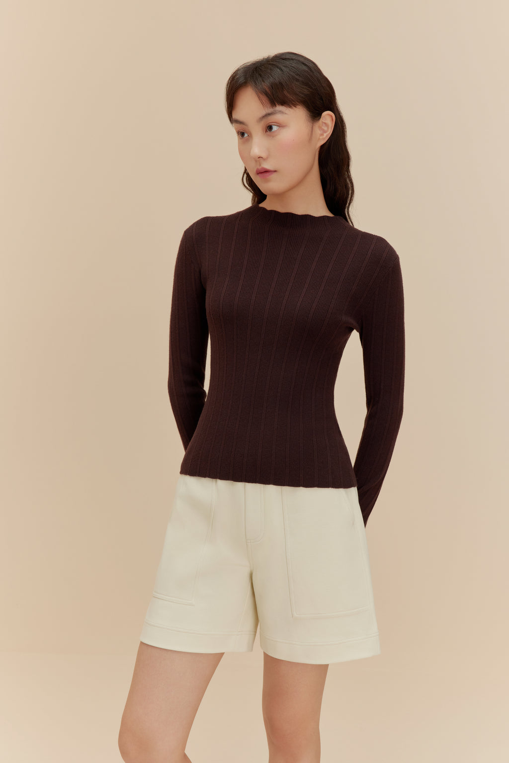 woman in brown sweater and white shorts