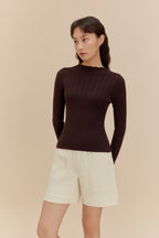 woman in brown sweater and white shorts