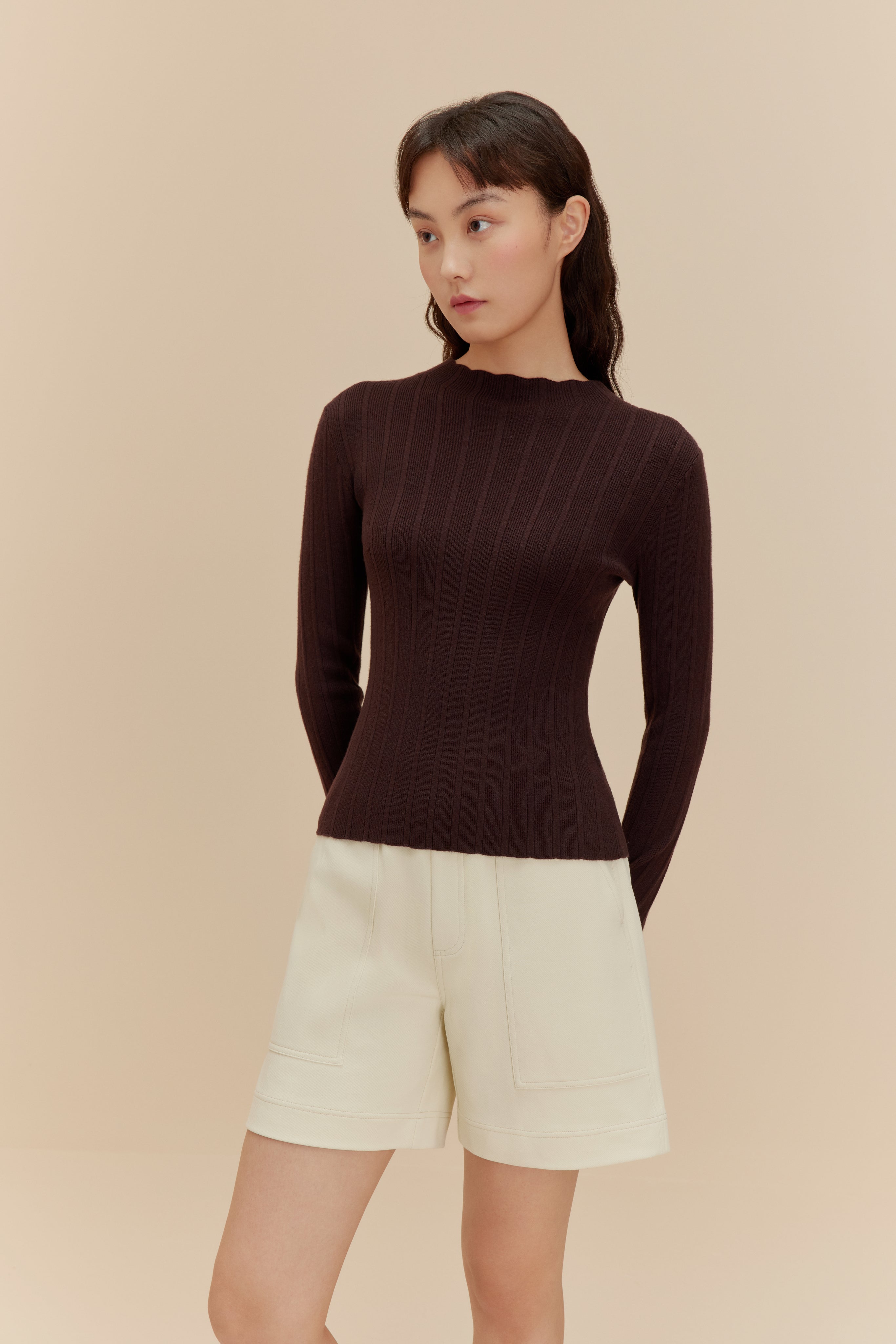 woman in brown sweater and white shorts