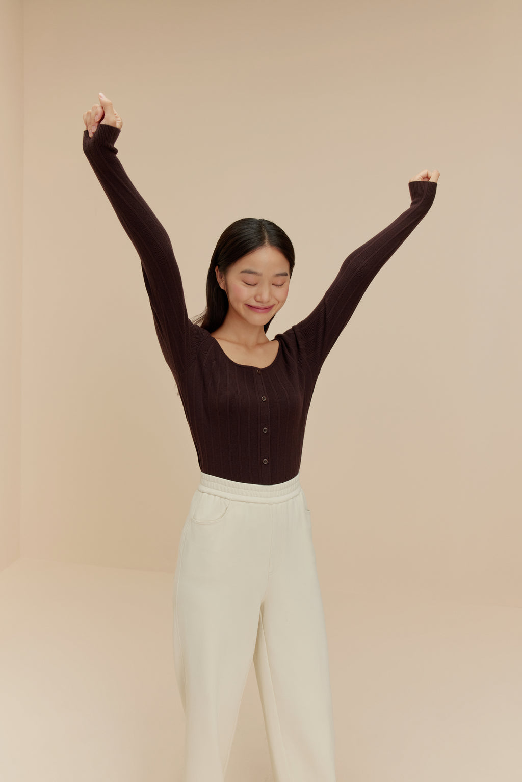 woman in brown cardigan and white pants
