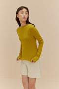 woman in golden yellow sweater and white shorts