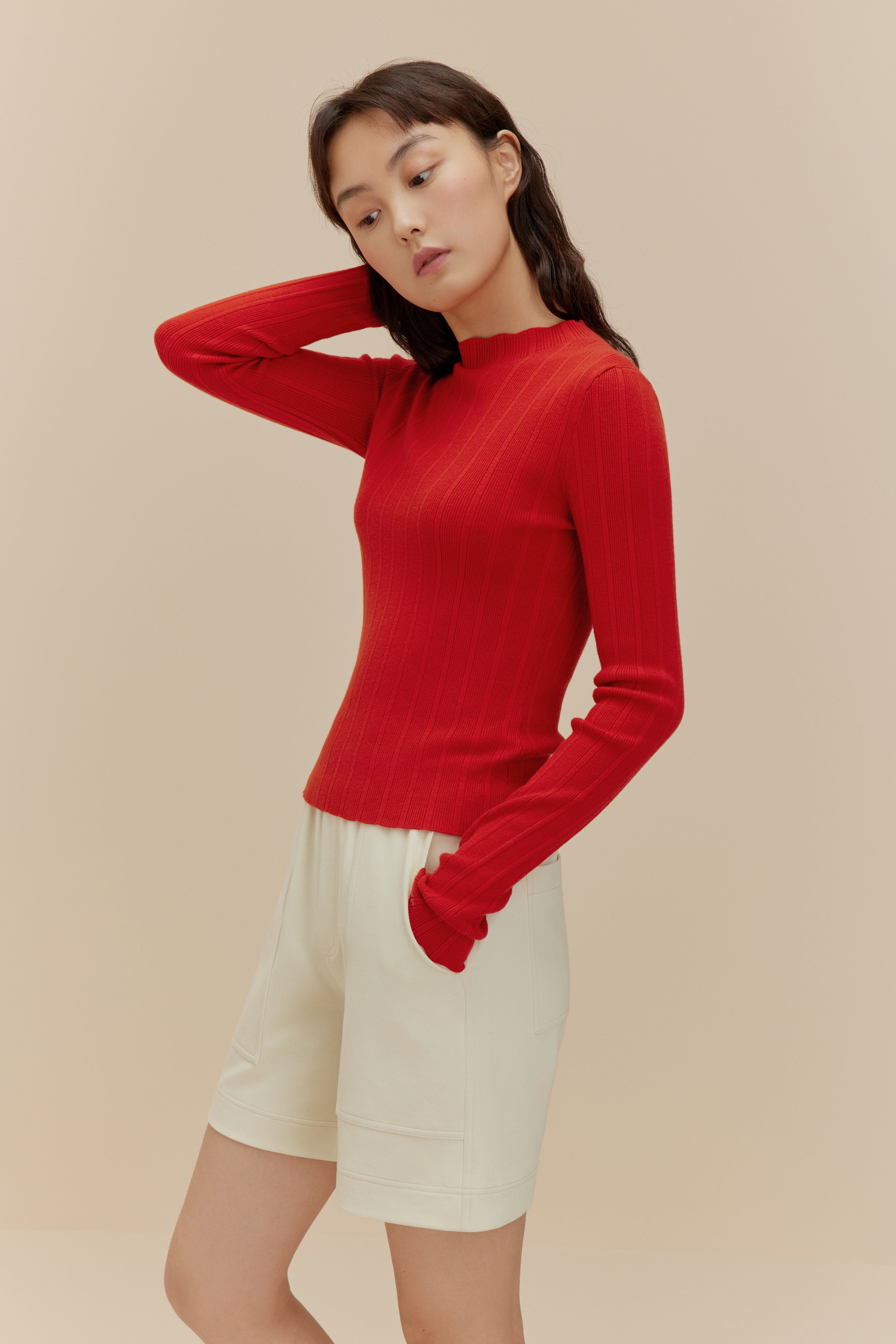 woman in red sweater and white shorts