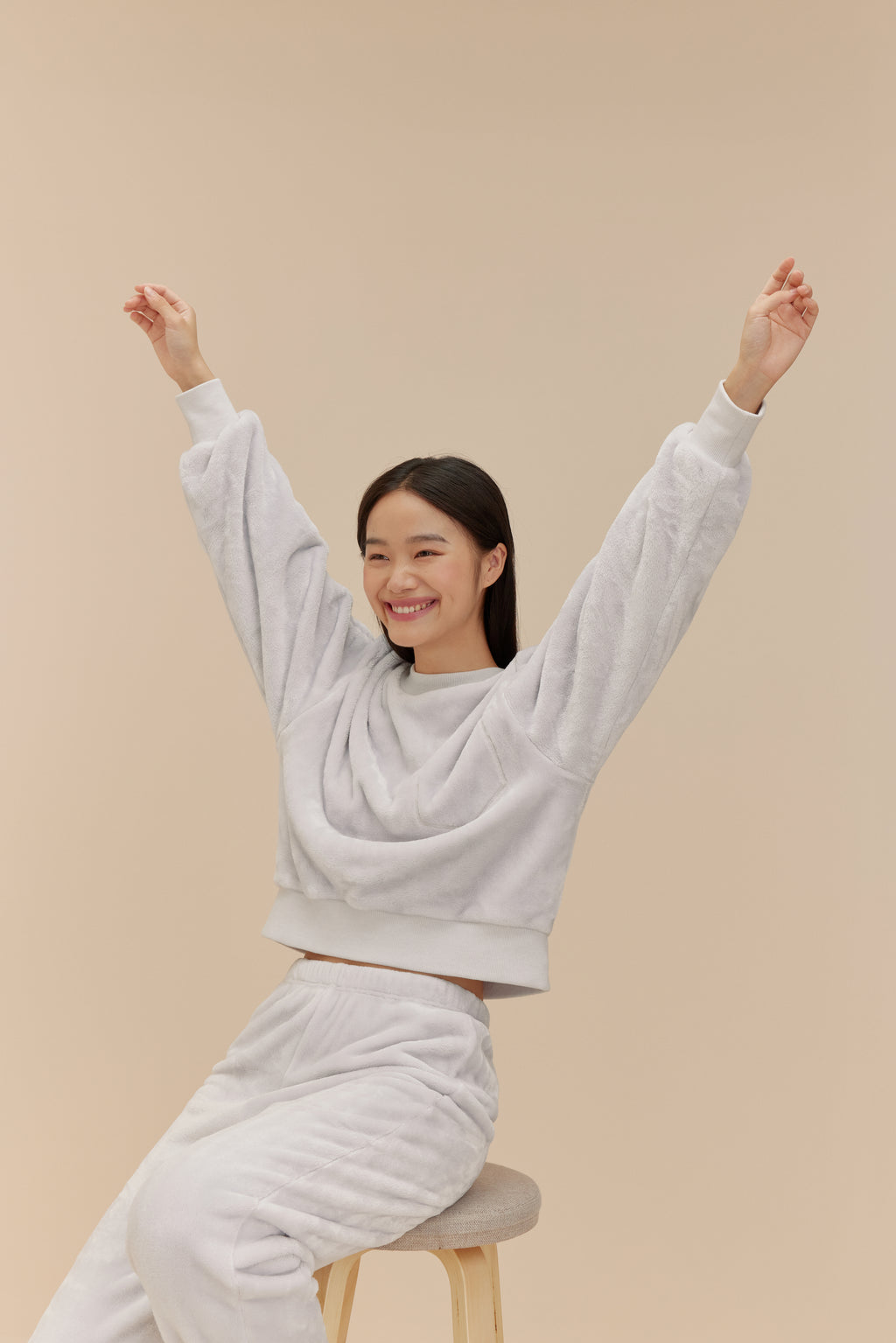 woman wearing light blue fleece set sitting on a stool