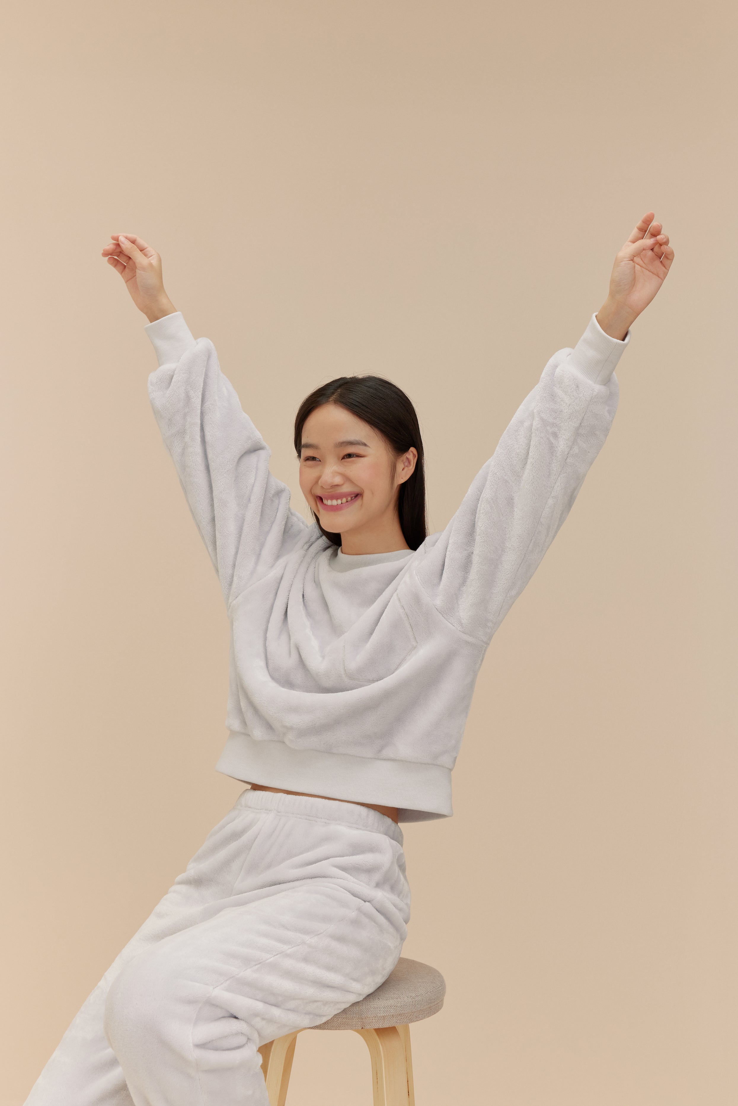woman wearing light blue fleece set sitting on a stool