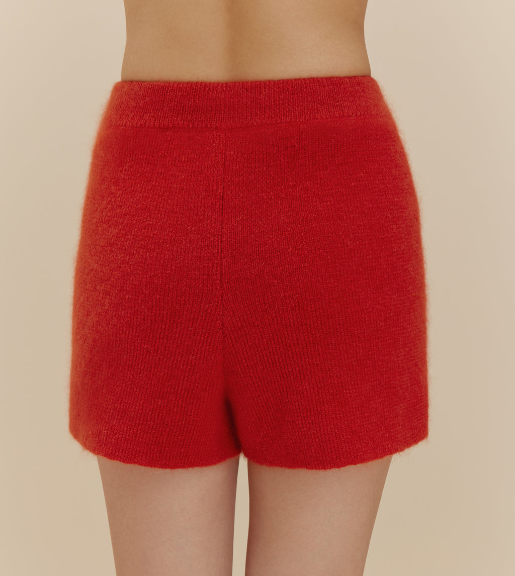 The back of a woman wearing fuzzy red shorts