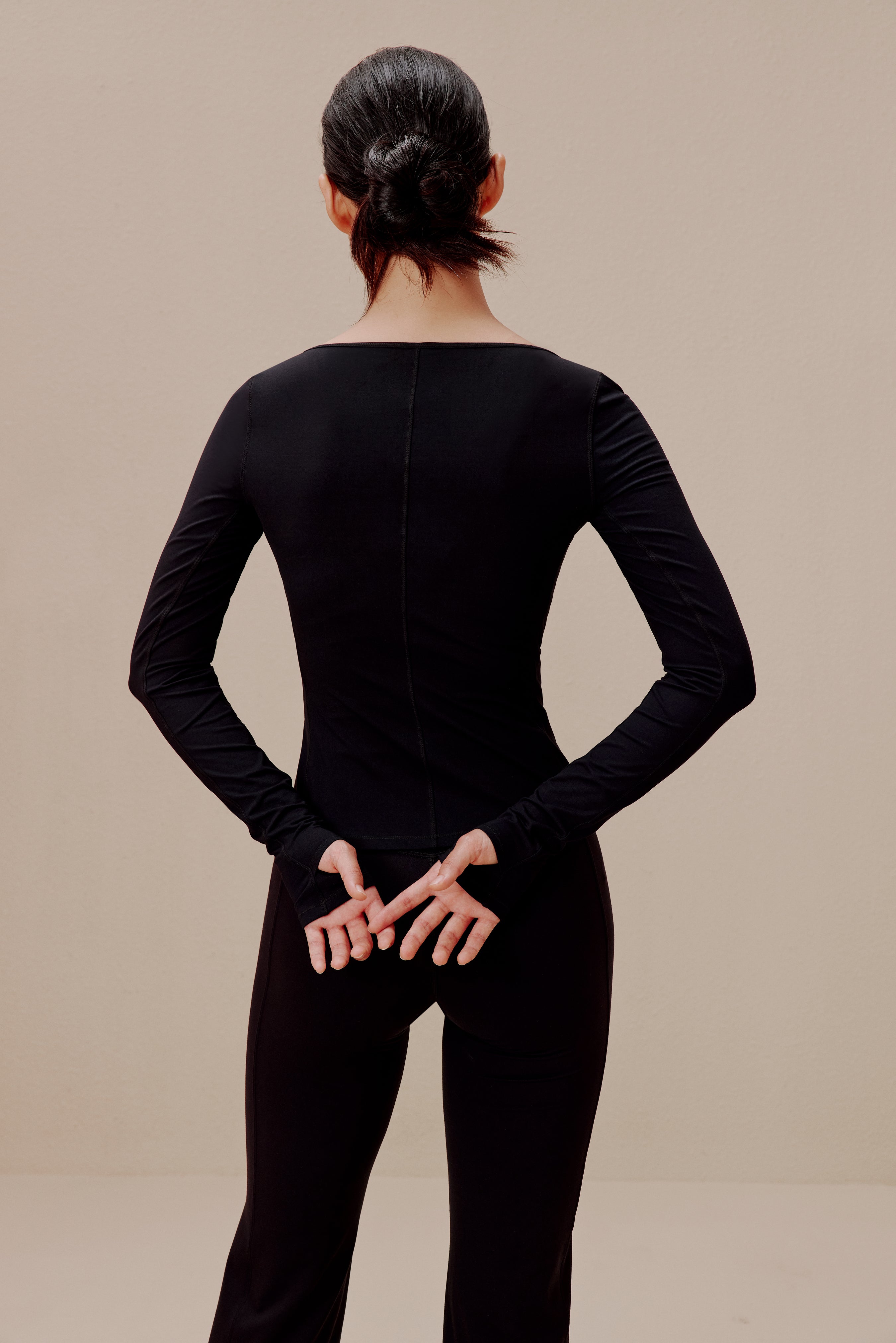 Back of woman in black top and sweatpants