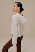 Side view of woman in white sweater