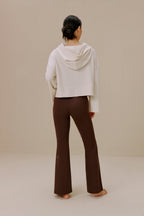 Back view of woman wearing white sweatshirt and brown wide-leg pants