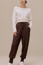 women in the white top and brown pants