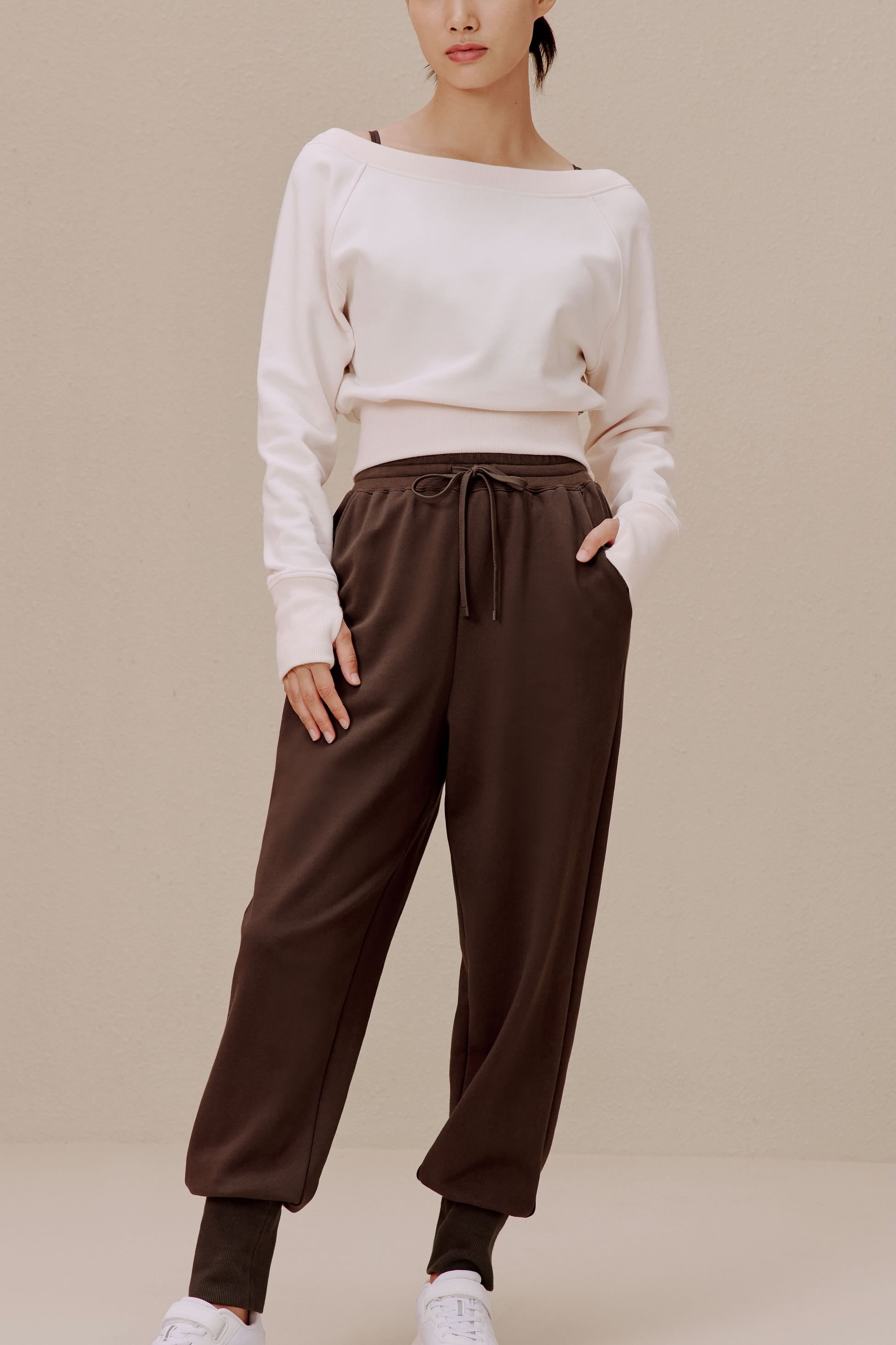women in the white top and brown pants
