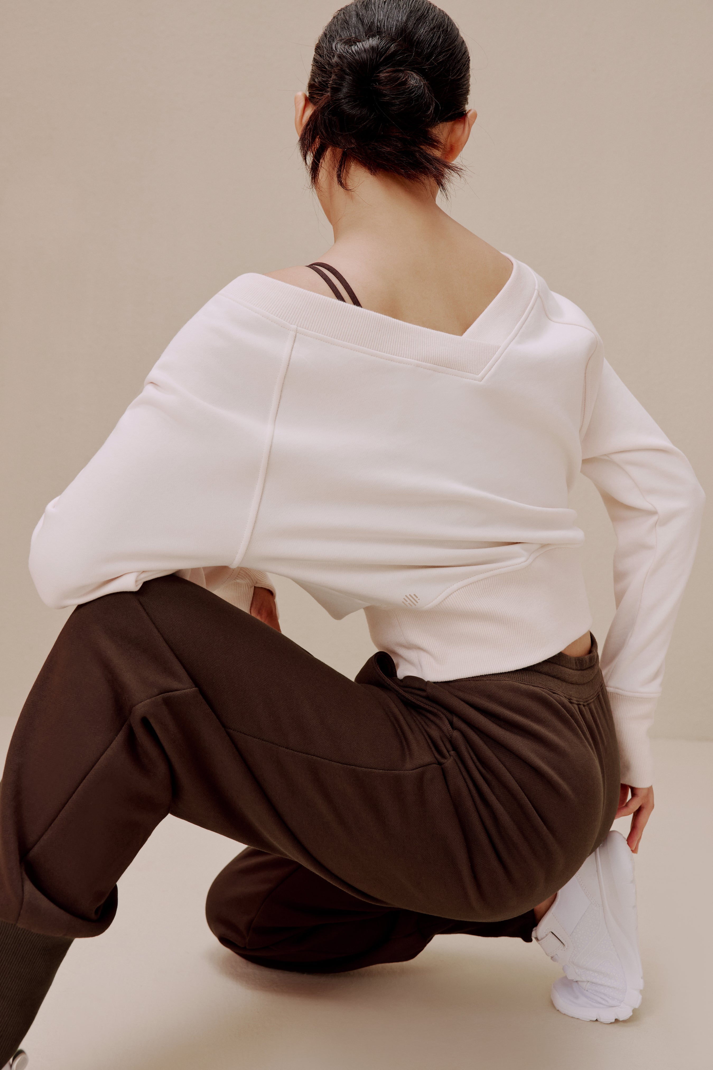 back of women in the white top and brown pants