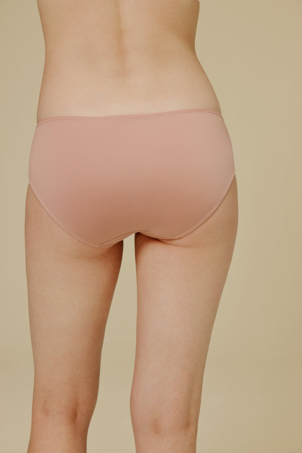 Back of woman in light pink underwear